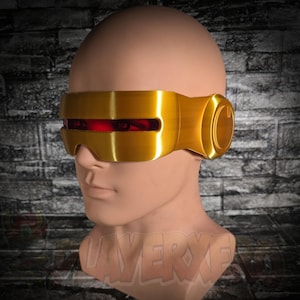 Op de afbeelding: Een goudkleurig vizier met een horizontale rode lensstrip, ontworpen om het ooggebied te bedekken. Het accessoire heeft een gladde, metallic afwerking en ronde zijpanelen, weergegeven op een neutraal gekleurd etalagehoofd.
