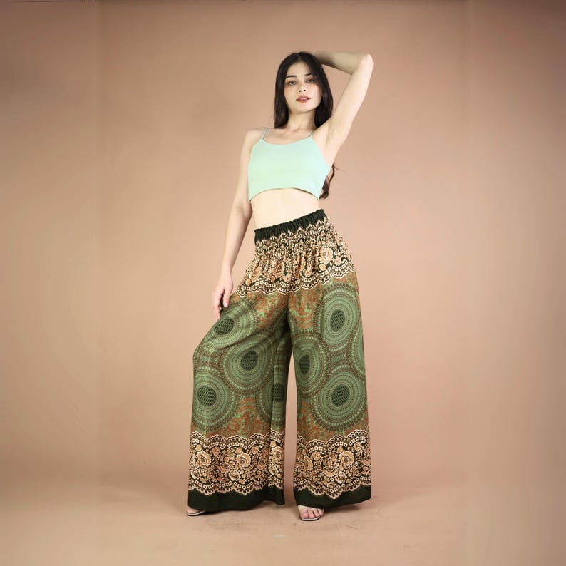 May include: Green wide-leg pants with a gold and brown mandala print. The pants have an elastic waistband and a relaxed fit.