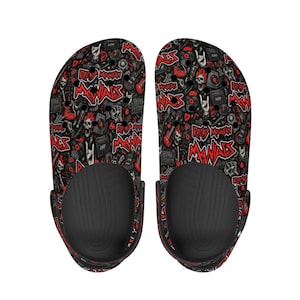 May include: Pair of black clogs with a red and black rock and roll themed pattern. The pattern includes skulls, guitars, records, and the words "ROCK MANIACS". The clogs have black soles and a black strap.