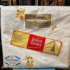 May include: White fitted sheet with a floral pattern. The sheet is labeled "Stevens Utica-Mohawk Fine Combed Percale Over 149 Threads Per Square Inch" and features "4 Corner Stretch Stretch Corners" for a secure fit.