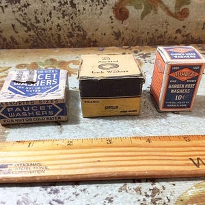May include: Three vintage boxes of assorted washers. The box on the left is blue and white and says "Assorted Sizes Faucet Washers for Hot or Cold Water". The box in the middle is brown and white and says "Assorted Lock Washers". The box on the right is orange and white and says "1902 Dumaco Red Rubber Garden Hose Washers 10c Fits All Sizes of Garden Hose".