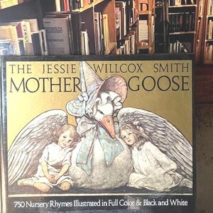 May include: A hardcover book titled The Jessie Willcox Smith Mother Goose, featuring an illustration of a goose wearing a bonnet between two children with wings. The cover text reads 750 Nursery Rhymes Illustrated in Full Color & Black and White.