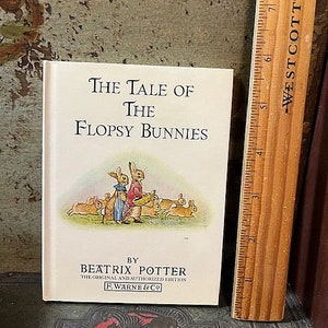 May include: A vintage children's book titled "The Tale of the Flopsy Bunnies" by Beatrix Potter. The cover features an illustration of bunnies in a garden setting.