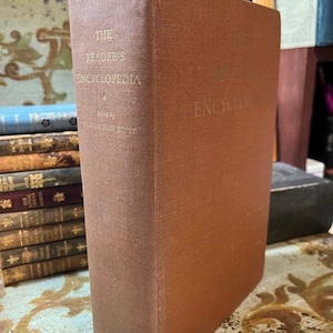 May include: A brown hardcover book titled "The Reader's Encyclopedia" with the word "Encyclopedia" embossed on the spine.