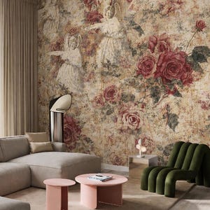 May include: A living room featuring a floral wallpaper with red roses and angel figures. The room includes a gray sectional sofa, pink coffee tables, a green armchair, and a beige rug. A modern lamp and side table complete the decor.