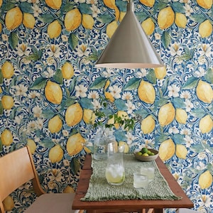 May include: A dining room scene with a wooden table set for two, featuring a green placemat and glasses. The background is wallpaper with a lemon and floral pattern. A grey pendant light hangs above the table.