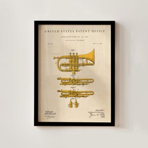 Op de afbeelding: Ingelijste vintage patentafdruk van een messing muziekinstrument, waarschijnlijk een trompet of een soortgelijke hoorn. De afdruk, van het United States Patent Office, bevat gedetailleerde diagrammen in geel en zwart op een beige achtergrond, omlijst door een zwart frame.