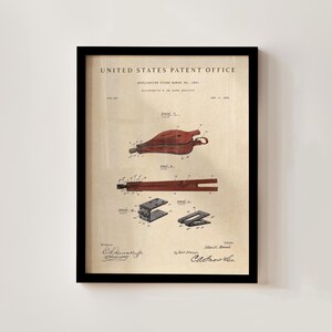 Op de afbeelding: Ingelijste patentafdruk van een handblaasbalg, gedateerd 8 april 1890, van het United States Patent Office. De afdruk bevat gedetailleerde diagrammen in rode en zwarte inkt op een beige achtergrond, met handtekeningen onderaan. De lijst is zwart.