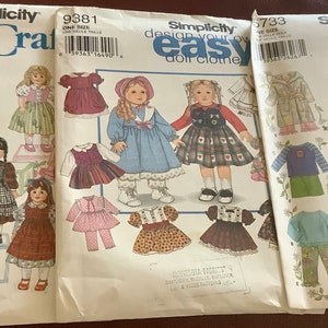 May include: Three Simplicity Crafts sewing patterns for doll clothes. The patterns feature illustrations of dolls in various outfits, including dresses, coats, and pants. The patterns are labeled with numbers and include the text "design your own easy doll clothes."