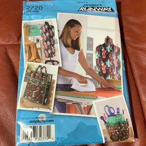 May include: Simplicity 2720 sewing pattern with multiple images showcasing design ideas. The pattern is one size and inspired by Project Runway. The main image features a woman ironing fabric. The pattern includes a tote bag and a dress form.