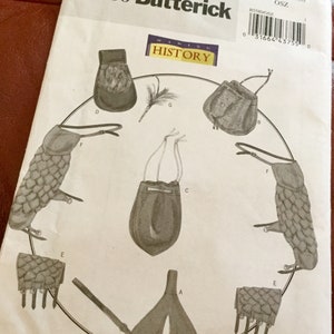 May include: A Butterick sewing pattern, B5580, featuring illustrations of historical pouches and accessories. The pattern includes various designs, such as a drawstring bag and scaled leg coverings. The "Making History" logo is visible.