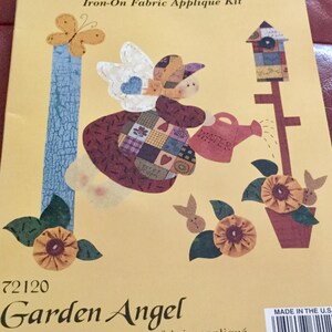 May include: Iron-on fabric appliqué kit titled "Country Borders" featuring a garden angel design. The kit includes die-cut fabric shapes with FUS-O-BOND already applied. The design includes a butterfly, birdhouse, flowers, and the word "WATER".