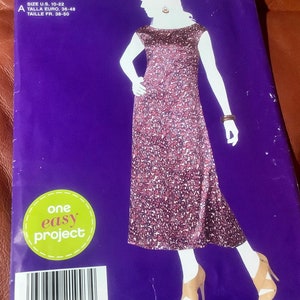May include: Simplicity sewing pattern C1993 featuring a dress design. The pattern cover has a purple background with a dress illustration in a floral pattern. The text "one easy project" is visible.