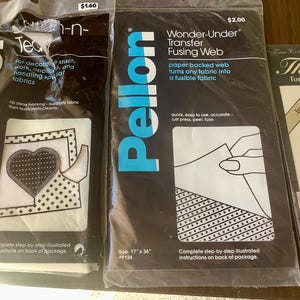 May include: Three packages of Pellon craft supplies. One package is labeled "Tea-n-" and includes instructions for decorative stitch work. Another is "Wonder-Under Transfer Fusing Web". The third is "Thread for cross-stitch".