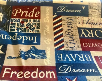 May include: Fabric with a patriotic theme, featuring red, white, and blue blocks with words like "Pride," "Freedom," and "Dream." The Statue of Liberty and stars are also visible. The words "USA" are repeated.