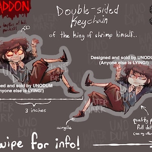 Peut inclure: Porte-clés double face en acrylique avec un personnage de dessin animé aux yeux rouges et aux cheveux foncés. Le porte-clés mesure 7,6 cm de long et porte les inscriptions "ABADDON" et "Designed and sold by UNODUM". Le texte "Swipe for info!" est également présent.