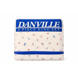 May include: A folded king-size sheet set with a floral pattern. The sheets are white with small red, blue, and purple flowers. The packaging is white with a blue band and the text "DANVILLE 4 PIECE KING SET" in white.