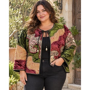 May include: A long-sleeve velvet jacket featuring a patchwork design in shades of olive green, deep burgundy, and tan. The jacket has a round neckline with a black cord tie closure and is worn over a black top and black jeans.
