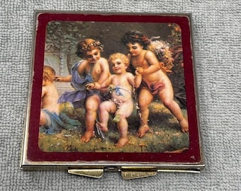 Pastillero vintage con ángel querubín, tono dorado, organizador de 7 días con espejo, estilo renacentista.