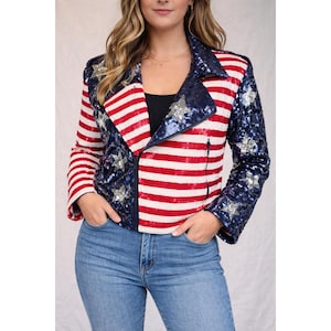 May include: A sequined jacket with a patriotic design. The jacket features red and white stripes on the front and sleeves, with a blue sequined collar and sleeves adorned with silver stars. The jacket has a zipper closure.