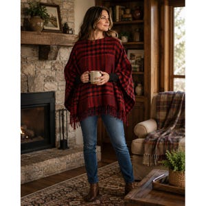 May include: A red and black plaid poncho featuring a fringe hem, worn over a black long-sleeve shirt and blue denim jeans. The poncho has a loose, draped fit with wide sleeves and a textured knit pattern, providing a layered look for cooler weather.