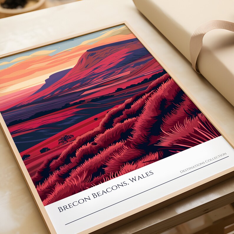 May include: A framed illustration of a mountain range with a red, pink, and purple color scheme. The text "BRECON BEACONS, WALES" is at the bottom of the image. The text "DESTINATIONS COLLECTION" is in the bottom right corner.