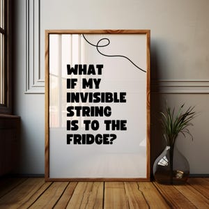 May include: A white framed poster with black text that reads "What if my invisible string is to the fridge?" with a black squiggly line at the top.