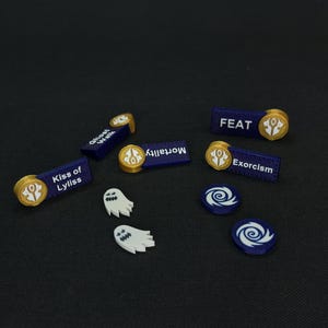 Op de afbeelding: Een set van acht tafelspelstukken, waaronder tokens met de woorden "Kiss of Lylliss", "Feat", "Mortality", "Exorcism", en twee spooktokens, en twee draaikolktokens.