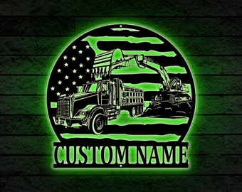 May include: A black metal silhouette of a semi-truck and excavator with an American flag background. The text "CUSTOM NAME" is below the silhouette.