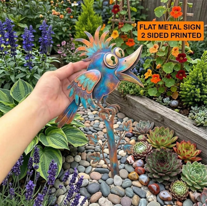 May include: A flat metal sign shaped like a bird with a crest, featuring a blue and copper patina finish, large eyes with keyhole pupils, and an open beak. The sign is two-sided and printed with a stylized bird design on a metal stake.