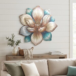 May include: A large, multi-layered metal wall art piece shaped like a blooming flower. The petals feature a gradient color scheme transitioning from cream and soft gold in the center to vibrant teal and blue at the outer edges with metallic edges.