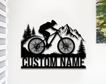 May include: Black silhouette of a mountain biker riding a bike up a mountain with trees on either side. The text "CUSTOM NAME" is at the bottom of the image.