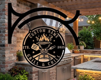 May include: A black circular metal sign featuring a grill graphic with flames, a spatula, and a fork. The text reads CUSTOM NAME, EST. 2025, and GRILL & CHILL. The sign hangs from a decorative black metal bracket attached to a brick wall.