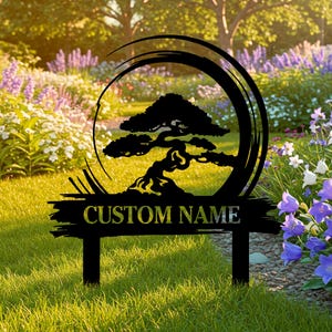 May include: Black metal garden stake featuring a bonsai tree design within a circular frame. The stake includes the text "CUSTOM NAME" in a stylized font, perfect for personalized garden decor. The stake is displayed in a garden setting.