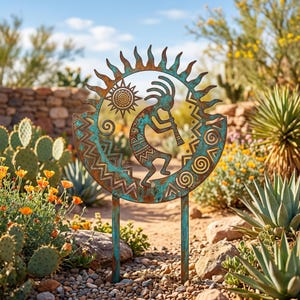 Op de afbeelding: Een verweerde metalen tuinpaal met een Kokopelli-figuur die op een fluit speelt in een zon en halve maan ontwerp. Het kunstwerk heeft een turquoise en roestkleurenschema, met decoratieve patronen en een basis met twee tanden.