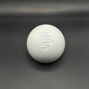 May include: White round gear shift knob with a raised Alfa Romeo logo.