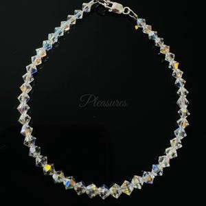 May include: A silver bracelet with clear crystal beads. The bracelet has a lobster clasp closure.