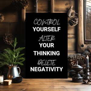 May include: Black sign with white text that reads "Control Yourself, Alter Your Thinking, Delete Negativity". The sign is hanging on a rustic wooden wall with pine cones and other rustic decor.