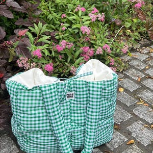 Può includere: Borsa tote in gingham verde e bianco con una texture gonfia. La borsa ha due manici e una piccola etichetta che dice "Made by Marie".