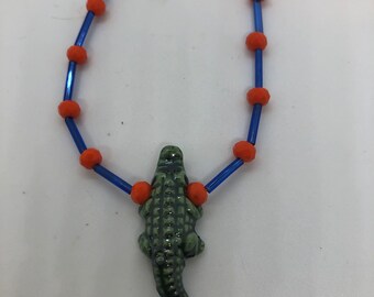 Collier équipe de perles oranges et bleues d'alligators de l'Université de Floride avec pendentif alligator en céramique. Perles pour clairons bleues et perles de cristal oranges