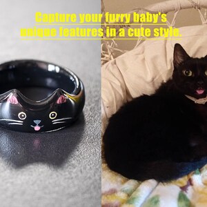 May include: A black ring featuring a cat face design with pointed ears, white eyes, whiskers, and a small pink tongue. The image includes the text: Capture your furry baby's unique features in a cute style. A black cat is shown for comparison.