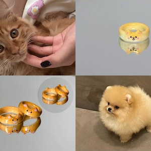 K&ouml;nnte beinhalten: Zwei gelbe Keramikringe mit einem Katzenkopfdesign. Die Ringe sind &uuml;bereinander gestapelt und spiegeln sich auf einer gl&auml;nzenden Oberfl&auml;che.