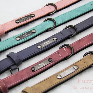 May include: Five different coloured leather dog collars with personalised metal name tags and phone numbers. The collars are pink, teal, dark blue, burgundy and brown.