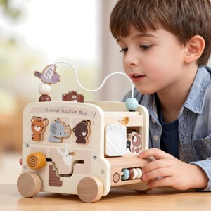 Puede incluir: Un juguete de autobús turístico de animales de madera con un laberinto de cuentas y bloques con forma de animales. El autobús es de color crema con ruedas de madera y presenta un tigre, un elefante y un oso. El texto "Animal tourism Bus" está impreso en el lateral.