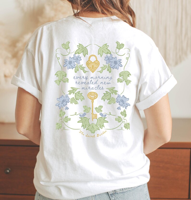 woman wearing white shirt with secret garden quote " every morning revealed new miracles"