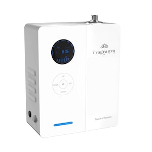 Puede incluir: Difusor de aceites esenciales eléctrico blanco con una pantalla digital que muestra la hora y un logotipo de flor de loto. El difusor tiene una etiqueta "Touch of heaven" y botones para el modo, arriba, configurar y abajo.