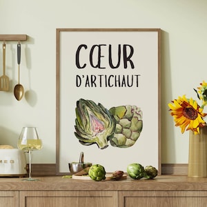 Peut inclure: Une impression encadrée blanche avec le texte "CŒUR D'ARTICHAUT" en lettres noires. Une illustration aquarelle de deux artichauts est présentée sur l'impression. L'impression est affichée sur un comptoir de cuisine avec un vase de tournesols et un grille-pain.