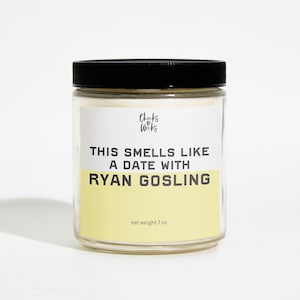 May include: A yellow candle in a clear glass jar with a black lid. The label reads "This smells like a date with Ryan Gosling".