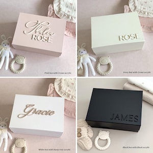 May include: Four square boxes in various colors: pink, ivory, white, and black. Each box has a name in a cursive font. The pink box says "Thalia ROSE", the ivory box says "ROSE", the white box says "Gracie", and the black box says "JAMES".