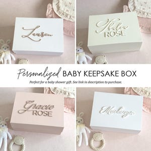 May include: Four white and pink personalised baby keepsake boxes with different names on each. The boxes are perfect for storing baby keepsakes and mementos.